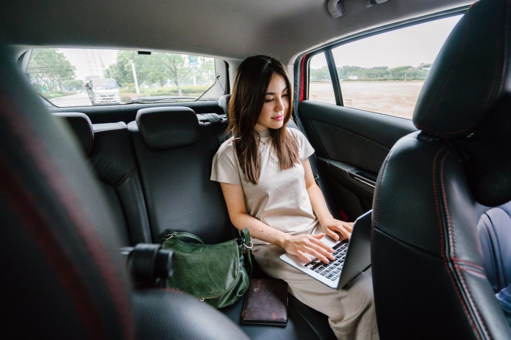 girl working in the car with a computer